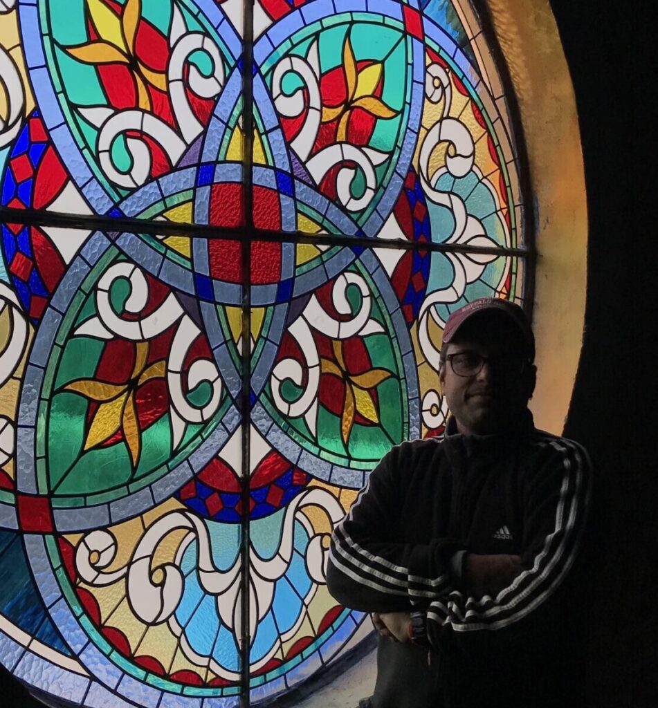 Deepak Tiwari in front of one of his stained glass work