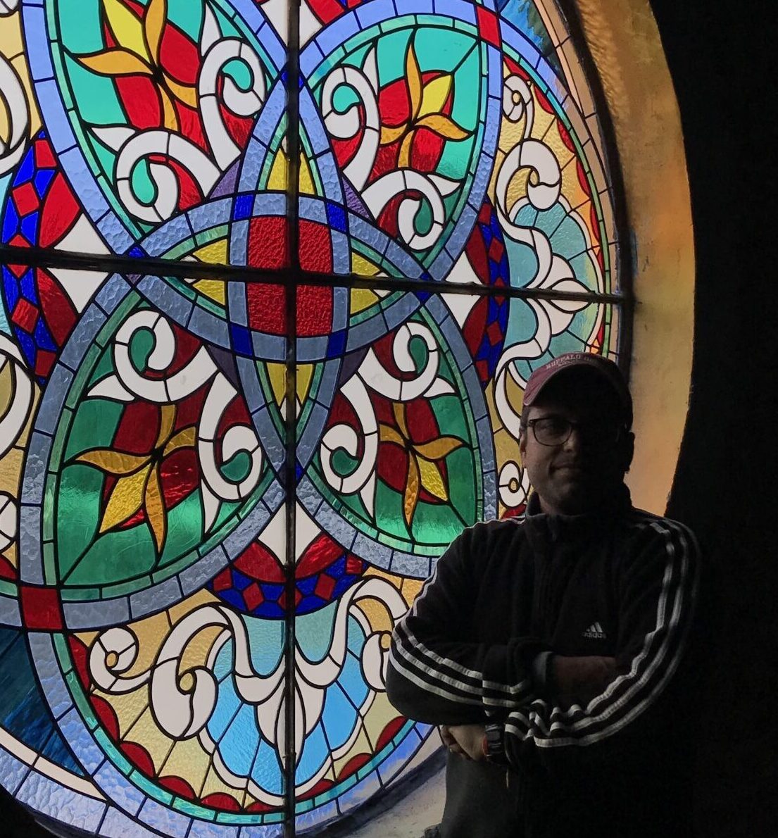 Deepak Tiwari in front of one of his stained glass work